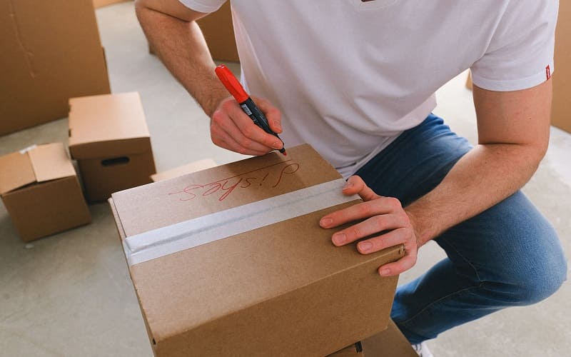 a man assigning names to the box of packed items