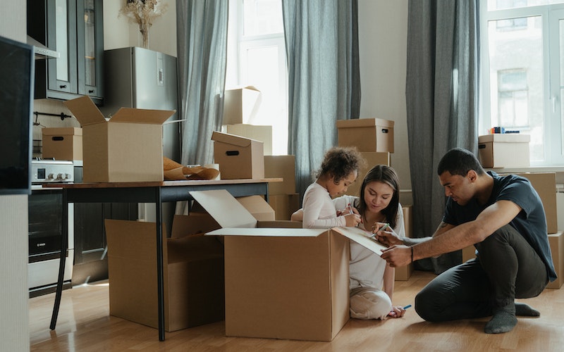 parents preparing for move with a child with packed boxes around them